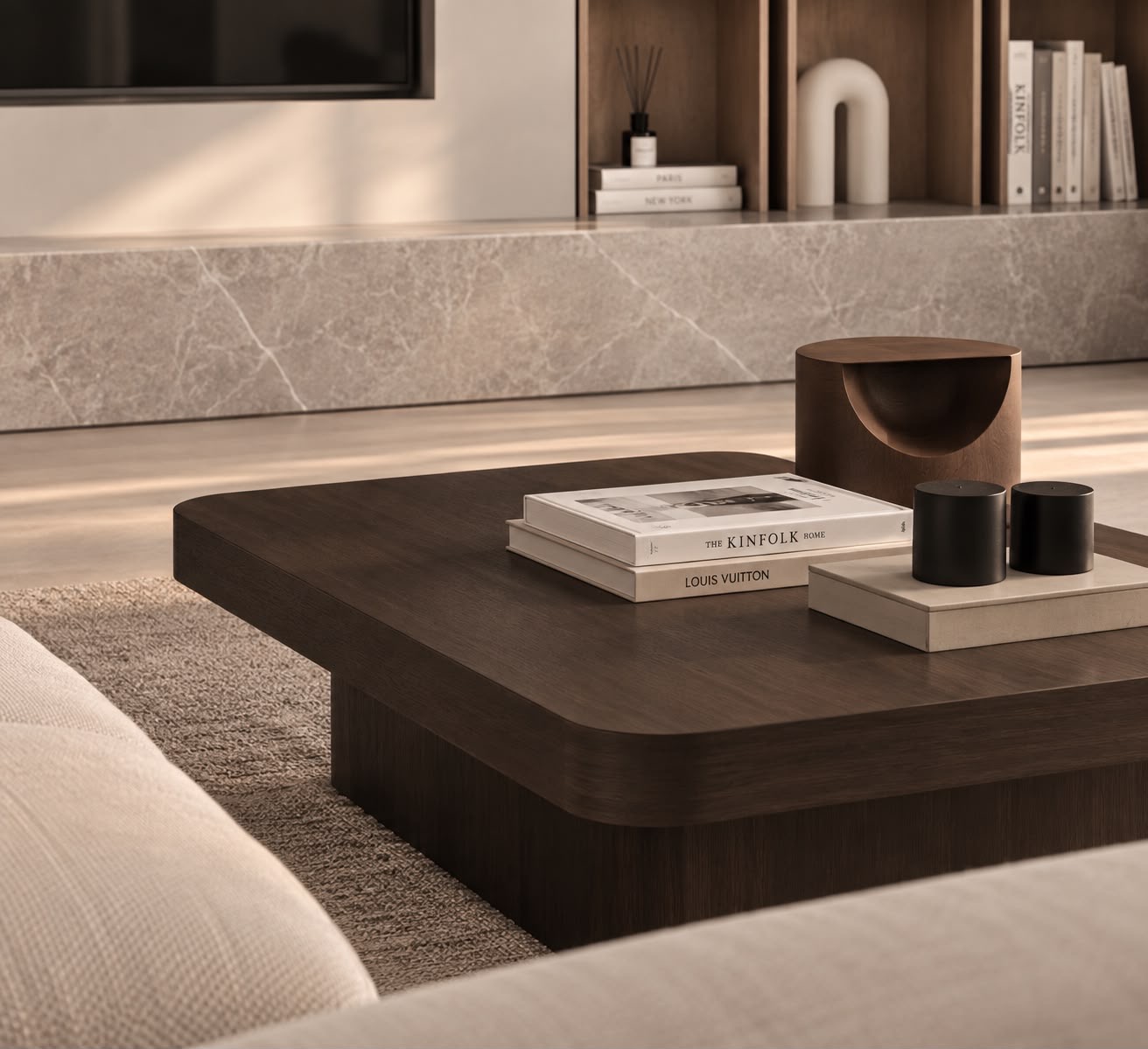 A dark-oak coffee table with rounded corners, books and a wooden sculpture, with the stone plinth behind. Render.
