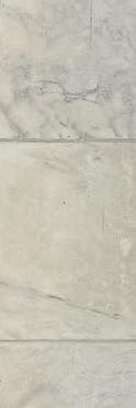 A detail: a white marble wall with gray veins, at the New York doorway.