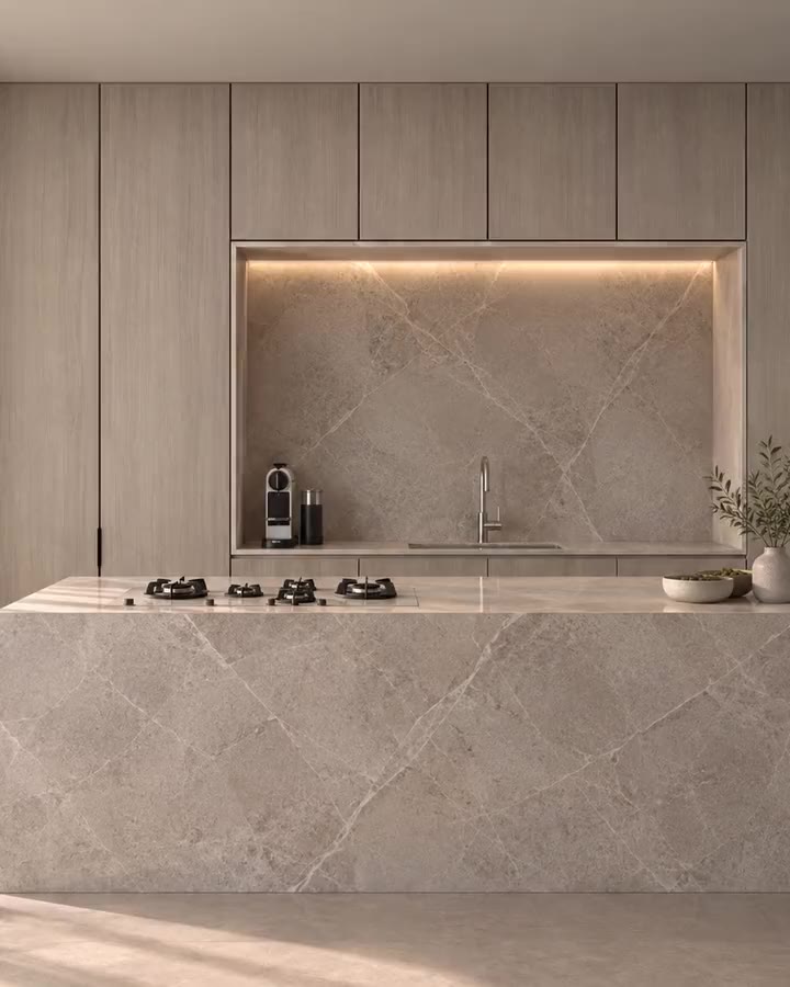 A kitchen with a monolithic stone island, floor-to-ceiling oak joinery and a lit niche. A SELÈ STUDIO design visualization.